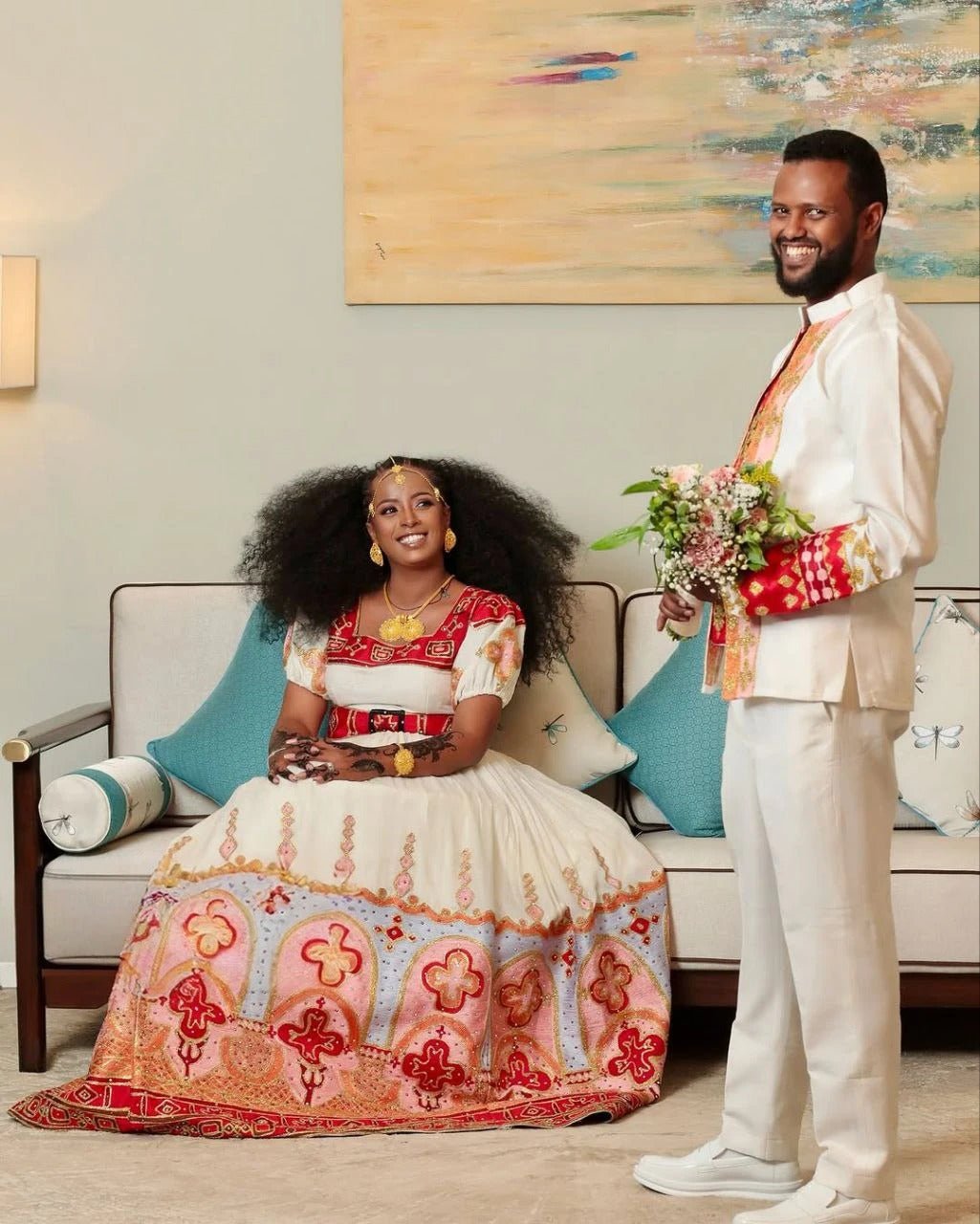 Elegant Habesha Couple's Attire with Vibrant Red and Gold Embroidery for Weddings