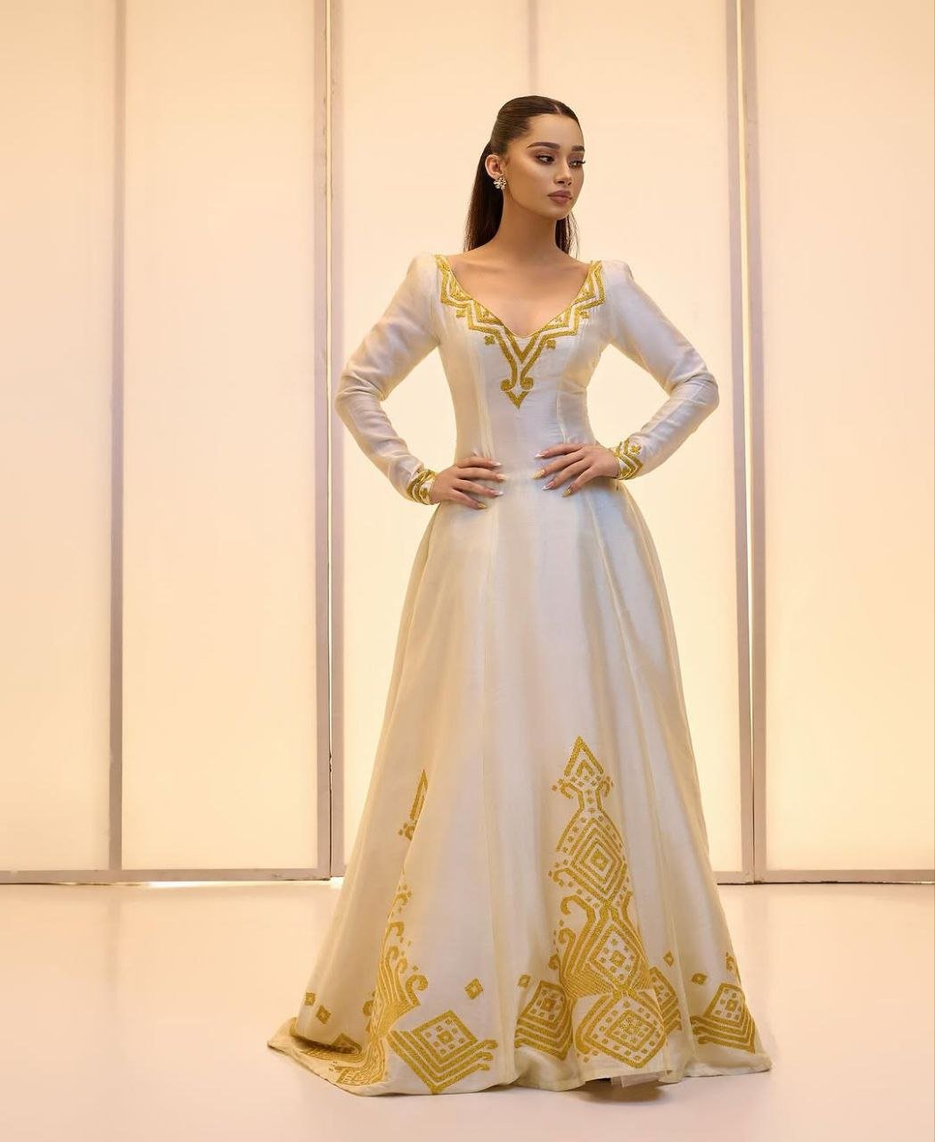Elegant Ivory Habesha Wedding Dress with Intricate Gold Embroidery For A Wedding