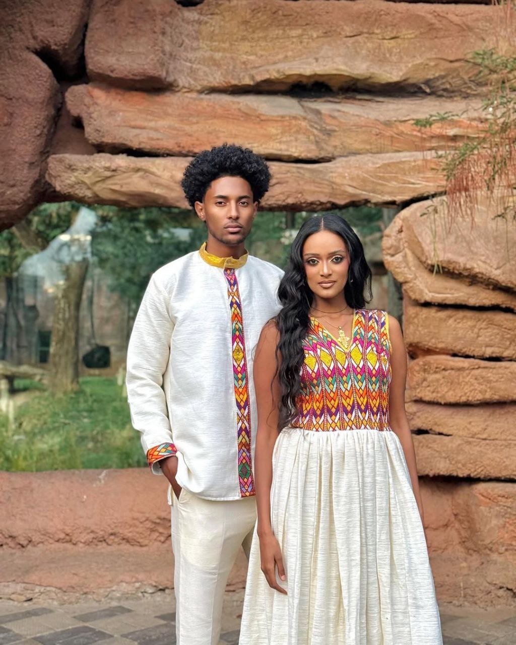 Stylish Traditional Ethiopian Couple's Attire with Vibrant Red, Yellow, and Green Embroidery for Celebrations