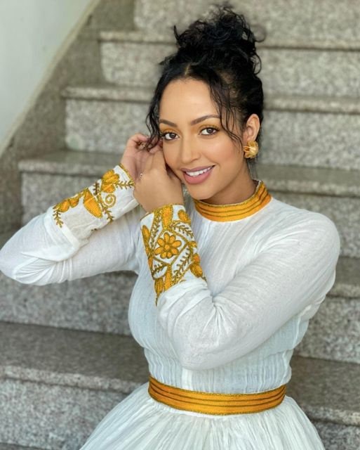 A Vibrant Yellow Menen Habesha Kemis with Intricate Flower Tilf Design