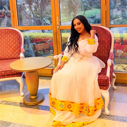 Yellow woven Habesha kemis crafted with traditional artistry and cultural significance.