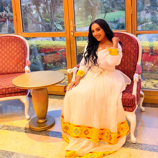 Yellow woven Habesha kemis crafted with traditional artistry and cultural significance.